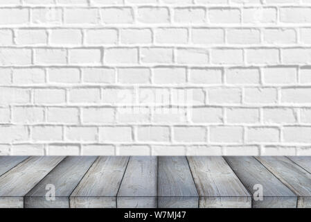 Wooden Shelf or Table in front of clean empty white brick Wall with space for Text or Ideas Stock Photo