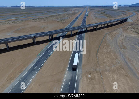 Aerial view of the Beijing-Urumqi Expressway, commonly known as the Jingxin Expressway, through the Gobi desert in Jiuquan city, northwest China's Gan Stock Photo