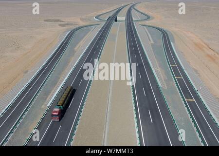 Aerial view of the Beijing-Urumqi Expressway, commonly known as the Jingxin Expressway, through the Gobi desert in Jiuquan city, northwest China's Gan Stock Photo