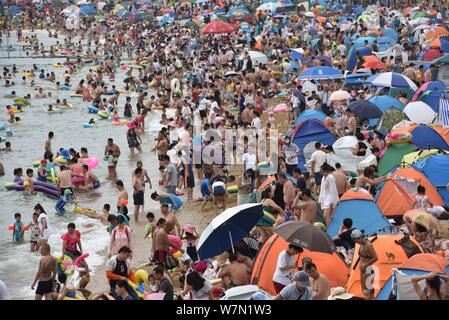 Holidaymakers crowd a beach resort to cool off on a scorching day in Dalian city, northeast China's Liaoning province, 16 July 2017.   A beach in Dali Stock Photo