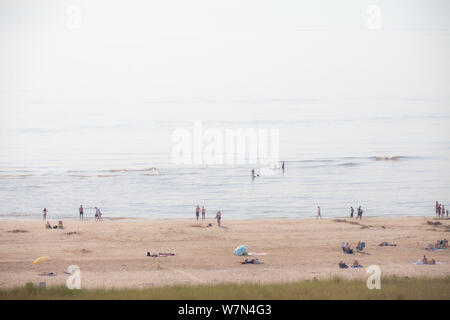 Egmond aan Zee, Netherlands - bathing people on the beach in the glistening sun (high key exposure) Stock Photo