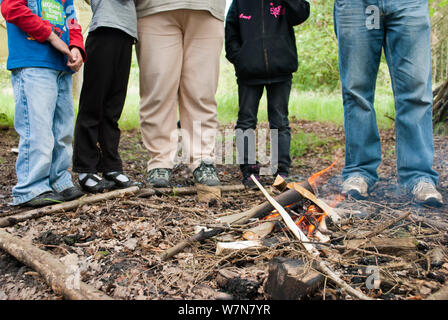 Five people standing next to a small fire on a bushcraft day, Palacerigg Country Park, Cumbernauld, North Lanarkshire, Scotland, UK, July  2011 Stock Photo