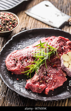 Beef meeat Rib-Eye steak wit rosemary salt and pepper on black plate Stock Photo