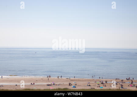 Egmond aan Zee, Netherlands - bathing people on the beach in the glistening sun (high key exposure) Stock Photo