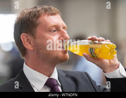 Heinsdorfergrund, Germany. 07th Aug, 2019. Michael Kretschmer (CDU), Prime Minister of Saxony, drinks a chilled lemonade at Thermofin GmbH during the tour. Thermofin is an internationally active company in the production of components for refrigeration and air conditioning. Credit: Robert Michael/dpa-Zentralbild/dpa/Alamy Live News Stock Photo