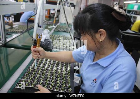 --FILE--A female Chinese worker produces electronic products on the assembly line at a factory in Suichuan county, Ji'an city, east China's Jiangxi pr Stock Photo