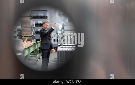 Heinsdorfergrund, Germany. 07th Aug, 2019. Michael Kretschmer (CDU), Prime Minister of Saxony, helps to assemble a heat exchanger during a tour of Thermofin GmbH's production facilities. Thermofin is an internationally active company in the production of components for refrigeration and air conditioning. Credit: Robert Michael/dpa-Zentralbild/dpa/Alamy Live News Stock Photo
