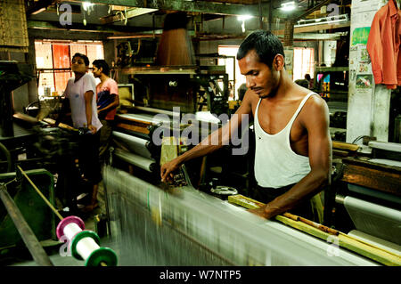 Men working in a silk factory, Rajshahi, Bangladesh, June 2012. Stock Photo