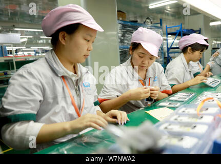 Female Chinese workers produce electronic accessories on the assembly ...