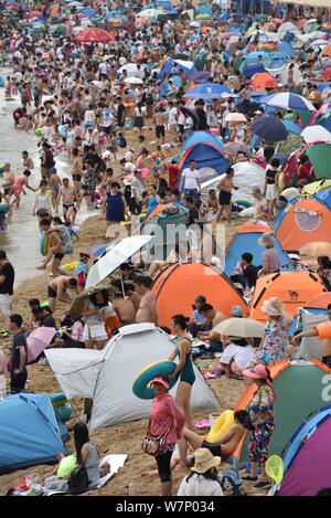 Holidaymakers crowd a beach resort to cool off on a scorching day in Dalian city, northeast China's Liaoning province, 16 July 2017.   A beach in Dali Stock Photo