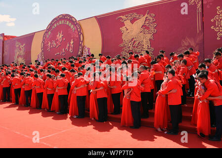 233 Chinese young couples dressed in traditional Chinese wedding costumes attend a group wedding ceremony held by Chinese automaker FAW (First Automob Stock Photo