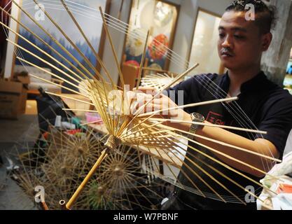 The seventh generation successor of Luzhou's oil paper umbrella Yu Wanlun makes an oil paper umbrella at his studio in Hangzhou city, east China's Zhe Stock Photo