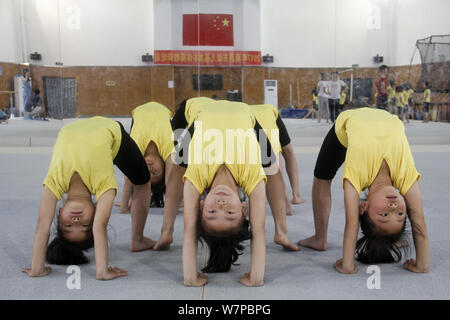 Young Chinese girls bend their bodies to practice gymnastics at a gymnastics and diving training center in Nanchang city, east China's Jiangxi provinc Stock Photo