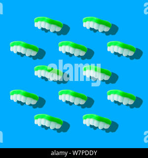 Photography collage of neon green color gummy milk teeth or jelly sweets on pastel blue background top view flat lay isometric pattern Stock Photo