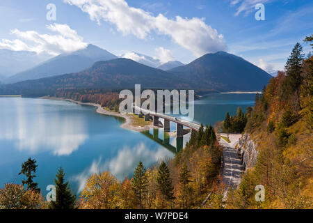 Reflections of a road bridge over Lake Sylvenstein, with mountains in the background, in Bavaria, Germany 2010 Stock Photo
