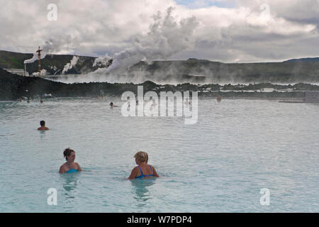 The Blue Lagoon, Iceland's most famous tourist attraction is located among the black lava flows outside Reykjavik. The geothermal spa owes its existence to the Svartsengi geothermal power plant powered by superheated seawater drawn from deep bore holes in the lava. The milky blue waters are rich in blue-green algae (cyanobacteria), mineral salts and fine silica mud. Reykjavik, Iceland 2006 Stock Photo