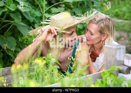 portrait of beautiful young couple in summer relaxing in garden Stock Photo