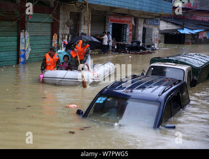 Chinese rescuers evacuate local residents by inflatable life boat from flooded areas after heavy rain in Lutang village of Xiushui county, east China' Stock Photo