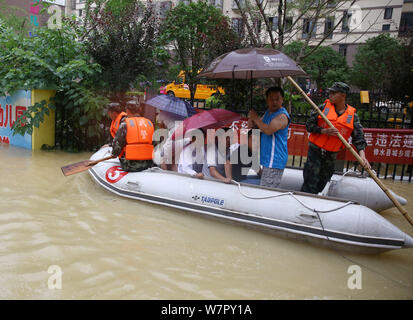 Chinese rescuers evacuate local residents by inflatable life boat from flooded areas after heavy rain in Lutang village of Xiushui county, east China' Stock Photo