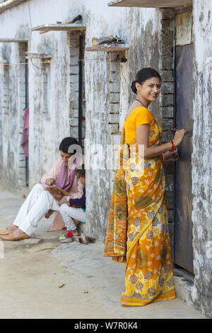 Rural woman locking door of her house Stock Photo