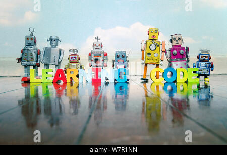 LEARNING CODE wooden letters and retro robot toys on a wooden floor with reflection Stock Photo