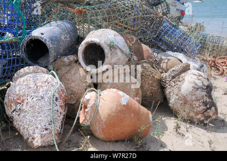 Stack of lobster pots and traditional ceramic Octopus pots encrusted with serpulid worm tubes and barnacles, Culatra island, Parque Natural da Ria Formosa, near Olhao, Algarve, Portugal, June. Stock Photo