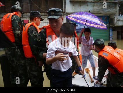 Chinese rescuers evacuate local residents from flooded areas caused by heavy rain in Lutang village of Xiushui county, east China's Jiangxi province, Stock Photo