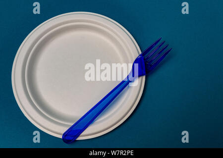plastic blue fork, plastic plate on a blue background. closeup Stock Photo