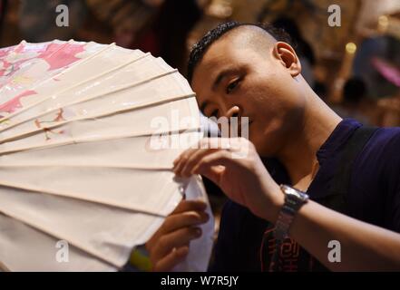 The seventh generation successor of Luzhou's oil paper umbrella Yu Wanlun makes an oil paper umbrella at his studio in Hangzhou city, east China's Zhe Stock Photo