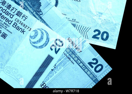 Different bills in twenty Hong Kong dollars close up. Money background blue color toned Stock Photo