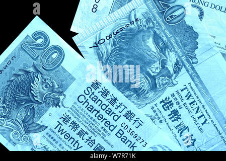 Different bills in twenty Hong Kong dollars close up. Money background blue color toned Stock Photo