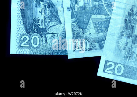 Different bills in twenty Hong Kong dollars close up. Money background blue color toned Stock Photo