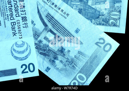 Different bills in twenty Hong Kong dollars close up. Money background blue color toned Stock Photo