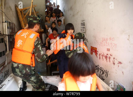 Chinese rescuers evacuate local residents from flooded areas caused by heavy rain in Lutang village of Xiushui county, east China's Jiangxi province, Stock Photo