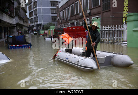 Chinese rescuers evacuate local residents by inflatable life boat from flooded areas after heavy rain in Lutang village of Xiushui county, east China' Stock Photo