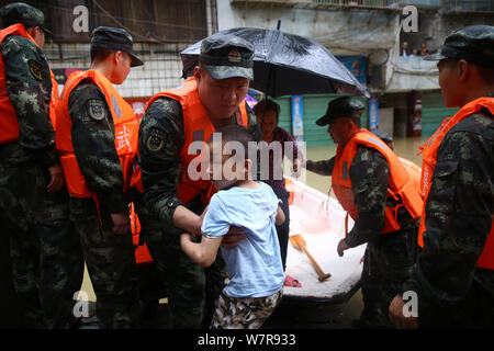 Chinese rescuers evacuate local residents from flooded areas caused by heavy rain in Lutang village of Xiushui county, east China's Jiangxi province, Stock Photo