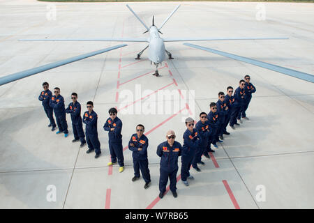 Chinese technicians pose with Cai Hong-4 (CH-4) unmanned aerial vehicles (UAVs) developed by designed and built by China Academy of Aerospace Aerodyna Stock Photo