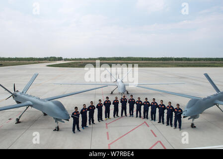 Chinese technicians pose with Cai Hong-4 (CH-4) unmanned aerial vehicles (UAVs) developed by designed and built by China Academy of Aerospace Aerodyna Stock Photo