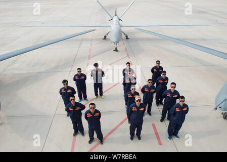 Chinese technicians pose with Cai Hong-4 (CH-4) unmanned aerial vehicles (UAVs) developed by designed and built by China Academy of Aerospace Aerodyna Stock Photo