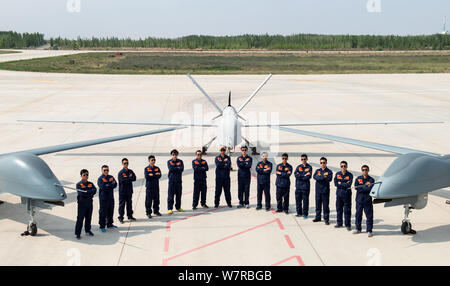 Chinese technicians pose with Cai Hong-4 (CH-4) unmanned aerial vehicles (UAVs) developed by designed and built by China Academy of Aerospace Aerodyna Stock Photo