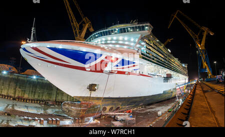 wide panoramic night time view of large cruise ship during dry dock refit in Brest, France Stock Photo