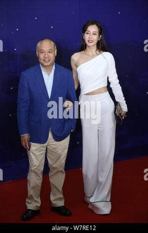 Former Chinese Olympic gymnastics champion Li Ning, left, chairman of Li Ning Company Limited, and Chinese yoga master and actress Muqi Miy arrive on Stock Photo