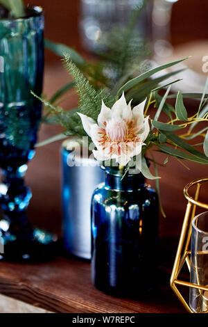Decoration table newlyweds, blue dishes, bottles of flowers and candles.Wedding floristry. Stock Photo