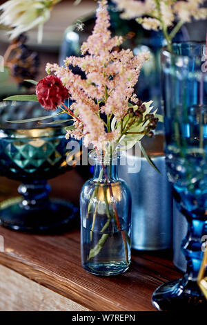 Decoration table newlyweds, blue dishes, bottles of flowers and candles.Wedding floristry. Stock Photo
