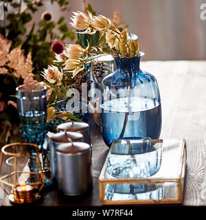 Decoration table newlyweds, blue dishes, bottles of flowers and candles.Wedding floristry. Stock Photo