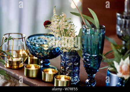 Decoration table newlyweds, blue dishes, bottles of flowers and candles.Wedding floristry. Stock Photo