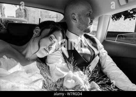 dreamy bride and groom in the car after ceremony Stock Photo