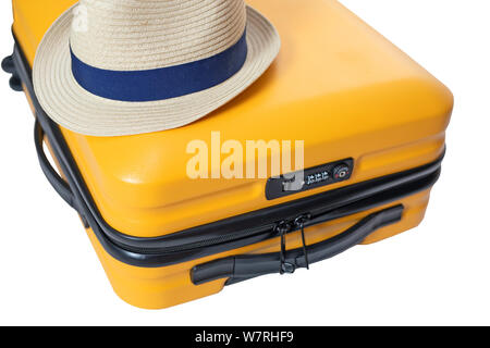 yellow suitcase with a combination lock with numbers 666 on it. Summer time -Travel bag and straw hat on top Stock Photo