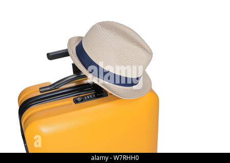 yellow suitcase with a combination lock with numbers 777 on it. Summer time -Travel bag and straw hat on top Stock Photo