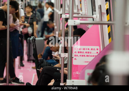 Chinese commuters are pictured in a subway train featuring pink decorations to encourage people to declare their feelings in Shenzhen city, south Chin Stock Photo